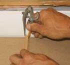 A piece of wood the width of the scribe on the adjacent wall jogs the divider pencil so the countertop will match the uneven walls on an inside corner countertop.
