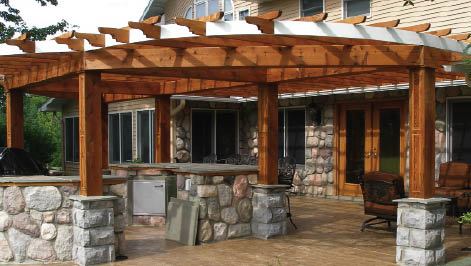 A western red cedar pergola by Creative Outdoor Wood Products, Fenton, Mich., tops stonework that was subbed out by the homeowner.