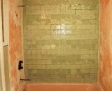 A mottled bond coat pattern may become visible through translucent or transparent glass tiles when they are installed over a waterproofing membrane.