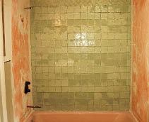 A mottled bond coat pattern may become visible through translucent or transparent glass tiles when they are installed over a waterproofing membrane.