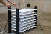 You assemble the Erecta-Rack as you go; when one level is filled, you put another set of bars on top so there will be room for another layer of material.