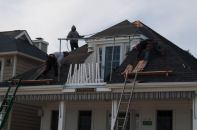 A Brielle New Jersey home receives a new roof post Hurricane Sandy. While flood damage predominated in shore communities, some wind damage did occur. But careful case-by-case inspection may be required to determine how much damage can be attributed to which factor.