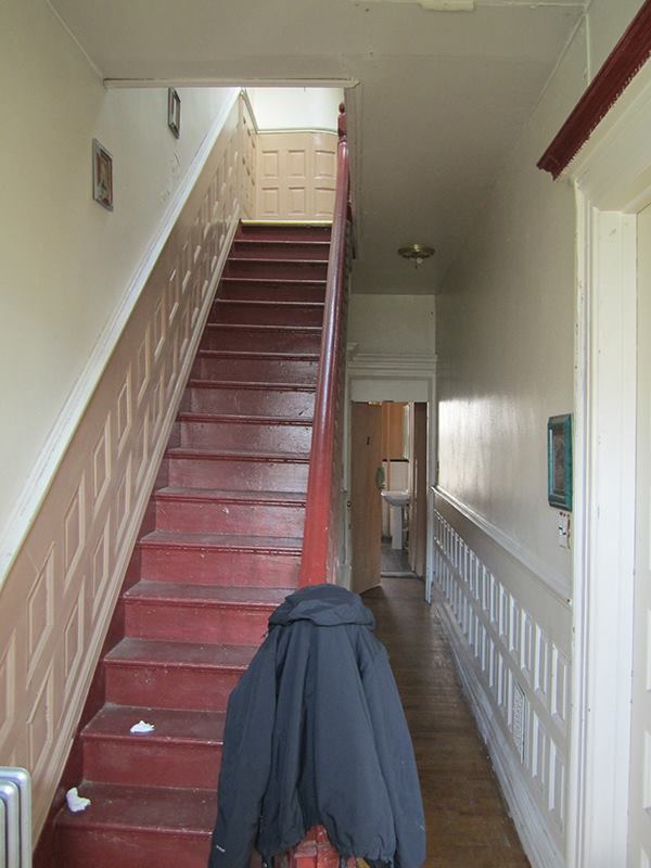 As is typical in townhomes of its vintage, the Brooklyn project house has a staircase that hugs one of the long party walls between units, and a "relieving wall" that helps support the floor joists, which run across the whole width of the unit. This wall was removed during renovations, requiring the floor system to be reinforced.