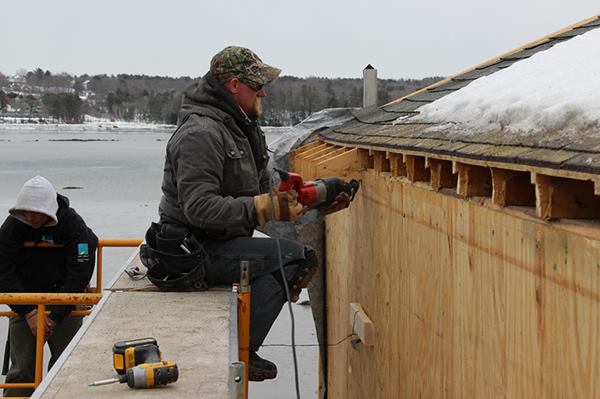 Carpenter Dan Armstrong cuts the eaves off the roof of an existing home in Newcastle, Maine.