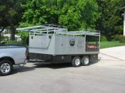 The trailer was originally a car carrier; the boxes, rack, and stake sides have been added. Note the double doors on the front of the trailer—they open directly into the bed.
