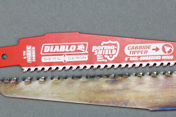Both of these blades are Demo Demons; the lower one has made 126 cuts through nail-embedded wood. Although the carbide tips have been dulled, they remain intact and can still cut – though at a slower rate than when sharp.