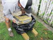 I slip the first sack into one of the contractor bags, laying the bagged concrete flat across the posts.