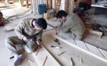 Japanese finish carpenters making the stringers for a close stringer winding stair.