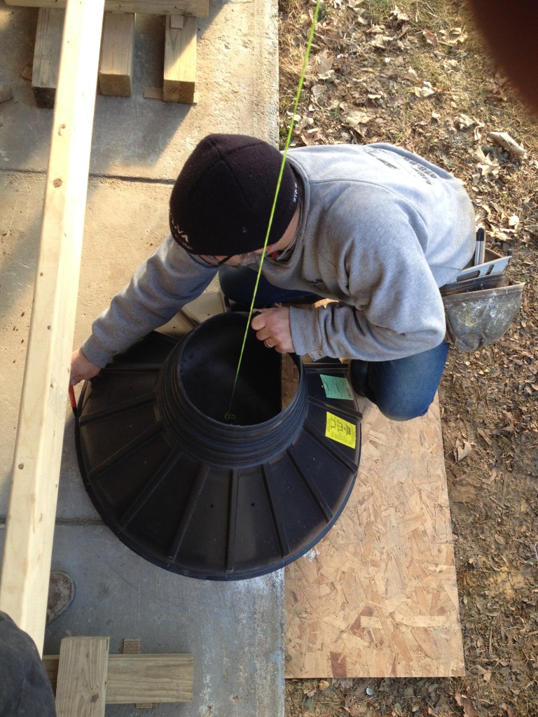 New footings were needed to support a family room addition. After the author removes the old posts and temporarily supports the structure, a plumb line locates the exact position of the footing form. Here, he draws the position on the concrete slab that he needs to remove before digging for the footing.