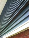 In older two-story homes with vinyl siding, it’s common to see siding panels that have uncoupled between floors. Shrinkage in the structure behind the siding is most likely the cause.