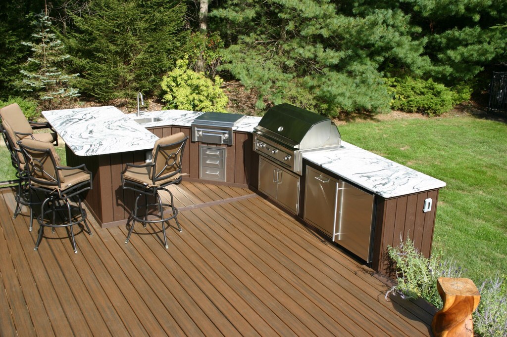 Granite countertops and stone veneer accent the top of the line stainless steel appliances on this composite deck.