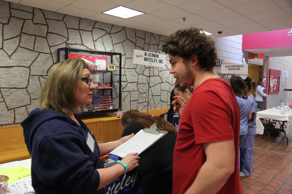 Ann Sweck, an HR representative from Whiteley Plumbing and Heating, in West Chatham, Mass., interviews a student at a job fair at Cape Cod Technical High School. Sweck said that students come to work for the summers and end up staying with the company long term.