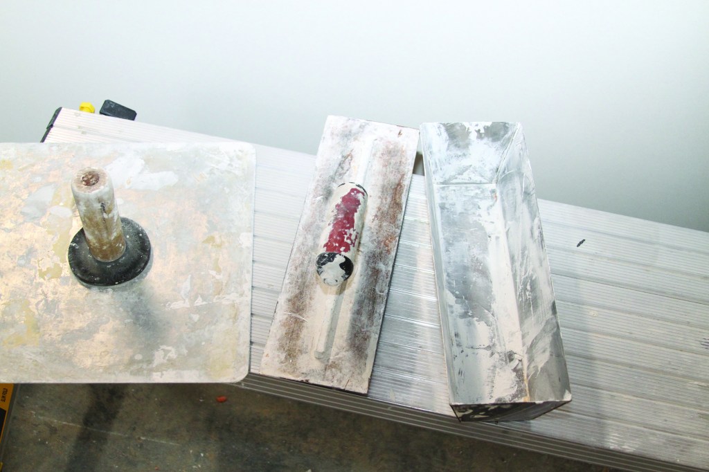 For hand-taping, there are three options for carrying mud — a hawk (left), a large trowel (center) or a pan (right).