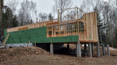 The largest element in the house (shown during framing) is a long, parallelogram-shaped main room with a two-story vaulted space.