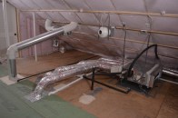 An encapsulated, semiconditioned attic houses the mechanicals for one of the author’s highperformance homes. A fan-powered freshair intake draws in a continuous 20 to 30 cfm. Below that, a five-zone air handler distributes conditioned air to occupied rooms below. Behind the sloping kitchen exhaust duct is a makeup air intake, which opens whenever the kitchen exhaust vent downstairs creates a negative pressure.