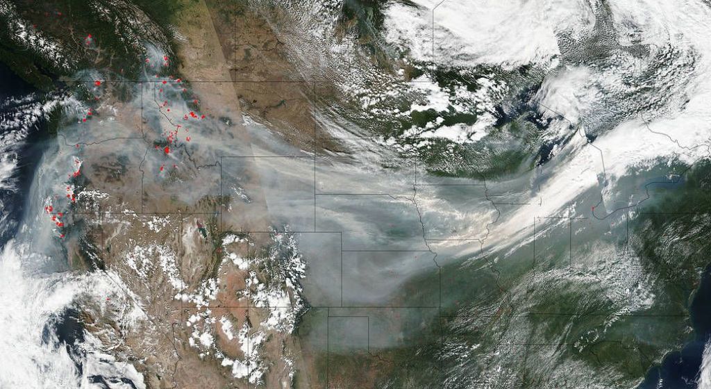 A NASA satellite captured this image of smoke traveling across the country on September 4, 2017. The actively burning areas are outlined in red.