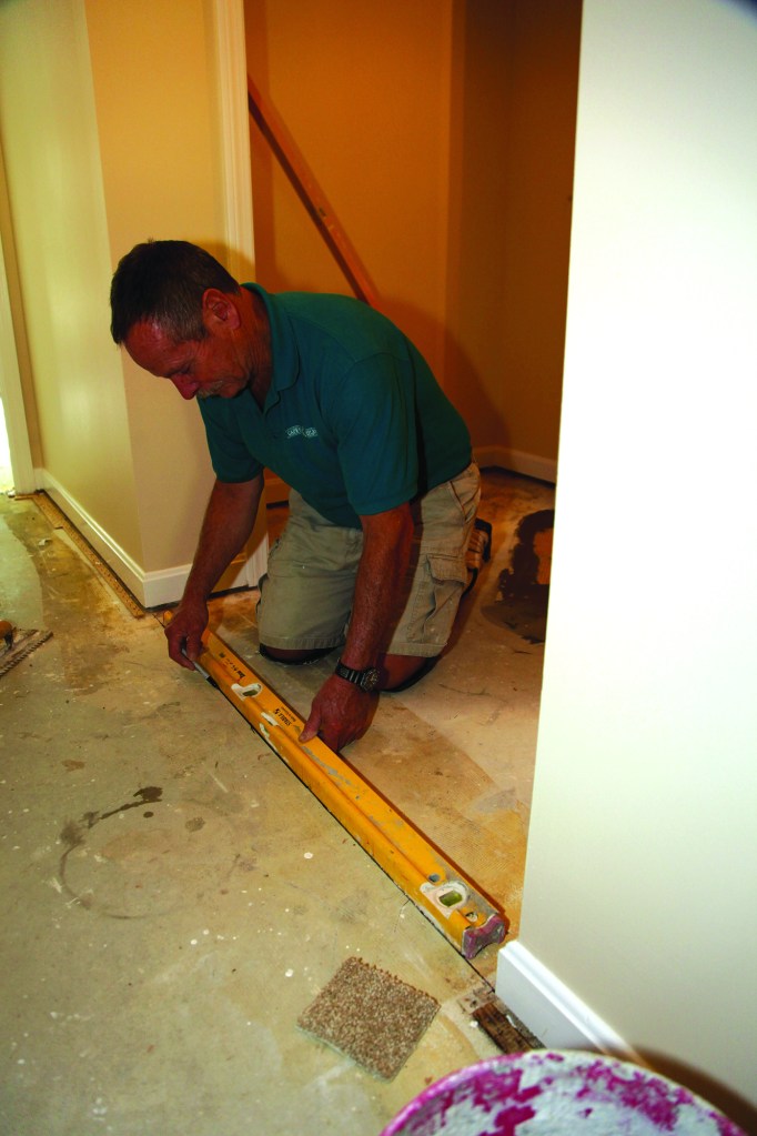Tile before carpet.  First establish the  transition line between  the carpet and the tile  and draw a line.  Spread mortar for the  tile, pulling it away  from the line.