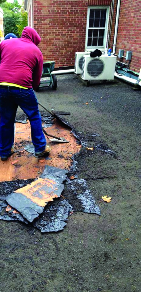 There are two types of built-up roofing (BUR): asphalt and pitch. Here, a tear-off crew begins work on a circa 1950s “pitch” roof.