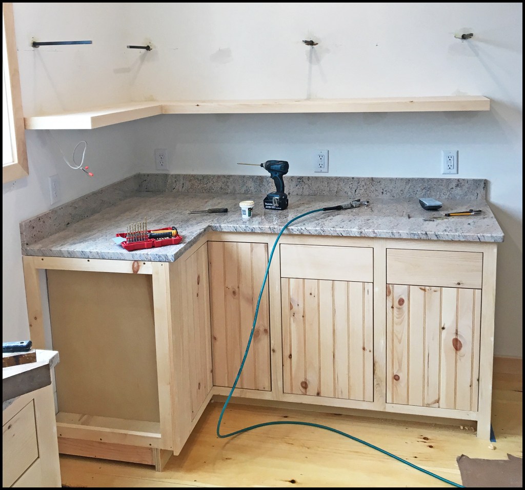 The author was tasked to install a pair of “floating” corner shelves, which he accomplished by building hollow shelves mounted on 1/2-inch square steel dowels.