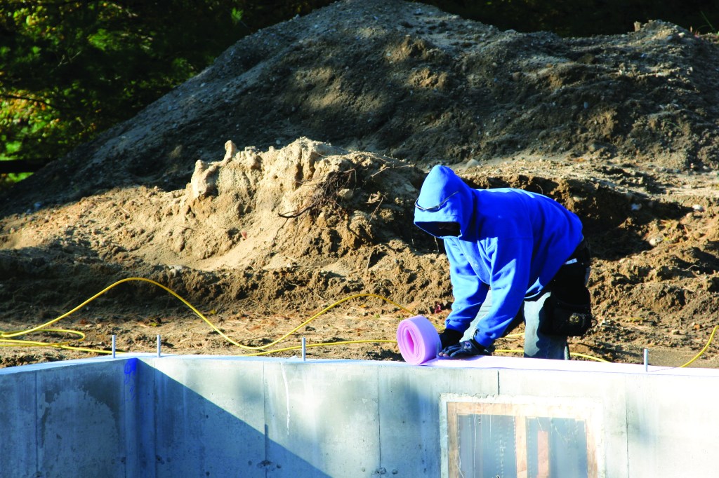 After the foundation concrete cures, sill seal is usually the first thing to be installed. This foam material air-seals the joint between the foundation and the mudsills. In most cases, those mudsills are made of treated lumber.