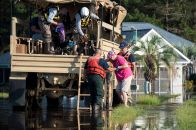 Coast Guard members assigned to the Atlantic and Pacific Strike Team assist an elderly woman into an Army National Gaurd high-water transport vehicle Sept. 20, 2108, in a flooded neighborhood in Longs, South Carolina. (U.S. Coast Guard photo by Petty Officer 3rd Class Ryan Dickinson)