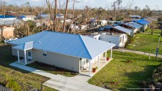 This affordable house, built under the "Habitat Strong" program, is one of six that survived Hurricane Michael unscathed. Surrounding older homes show severe roof damage.