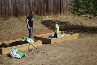 This dad gets assistance from his daughter to build a raised bed garden in which to grow their vegetables.