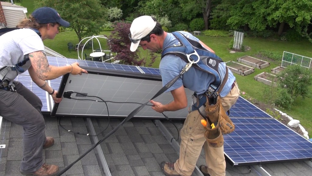 Technicians Brandon Bernard and Mel Janarelli of ReVision Energy install a photovoltaic array on a Maine rooftop in 2014 (photo by Ted Cushman/JLC).