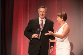 At the Awards Gala in New Orleans, Steve Barkhouse receives the 2018 Impact Award from Victoria Downing, president and chief inspiration officer of Remodelers Advantage.