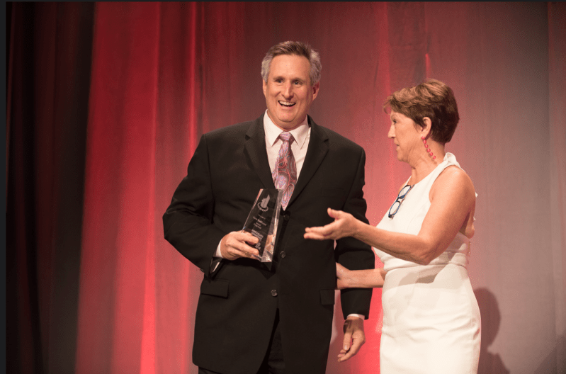 At the Awards Gala in New Orleans, Steve Barkhouse receives the 2018 Impact Award from Victoria Downing, president and chief inspiration officer of Remodelers Advantage.