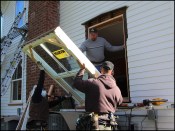 The homeowners wanted to replace their single-pane, two-over-two windows with "true" wood windows. Here, carpenters James Curtis (center), Ed Brady (right), and Isaias Santos (left) lift a full-frame Marvin Ultimate double-hung window in place.