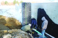 The author and crew install a 30-inch-diameter culvert vertically to act as a sump pit well next to the home’s foundation.