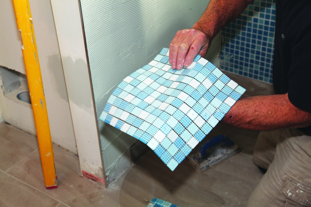 Mesh backing lets you install the tiny glass tiles as a single sheet (1). Start by spreading a thin, even layer of thinset on the wall. Comb the thinset in one direction using a notched trowel with the recommended-size teeth.