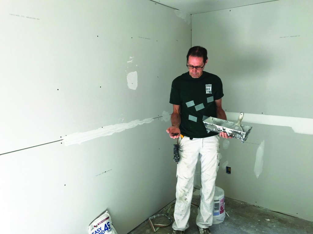 For the prep work, the author carries a utility knife, a screw gun, and a few screws in addition to a mud pan and a 6-inch taping knife.