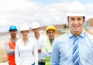 Portrait of a handsome architect with his teamwork in the background