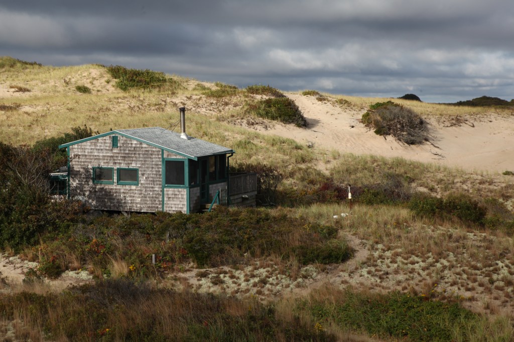 Sunrise bursts through overcast skies lighting up the Fowler Dune Shack, my refuge for a week.