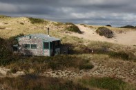Sunrise bursts through overcast skies lighting up the Fowler Dune Shack, my refuge for a week.