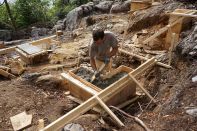 Mark Pollard consolidates concrete for a foundation pier on a rocky site in Maine.