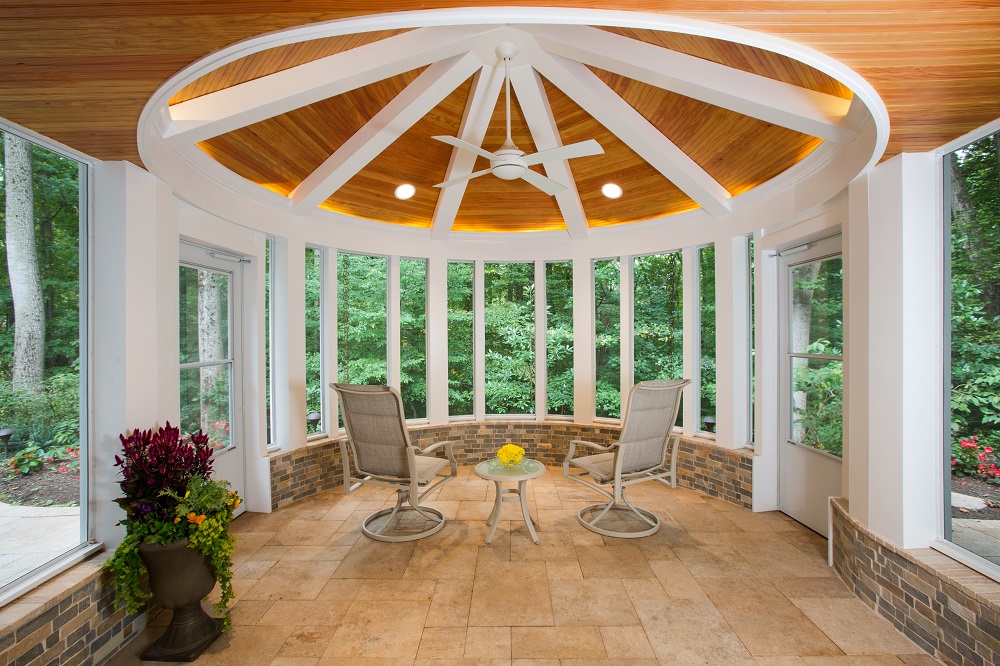 The screened porch has a conical vaulted ceiling, giving the compact sunroom a spacious feeling. The stone kneewall is capped with stone pavers salvaged from the existing patio.