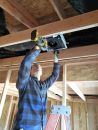 The author places a Panasonic WhisperValue fan, one of seven in the 3,800-square-foot house.