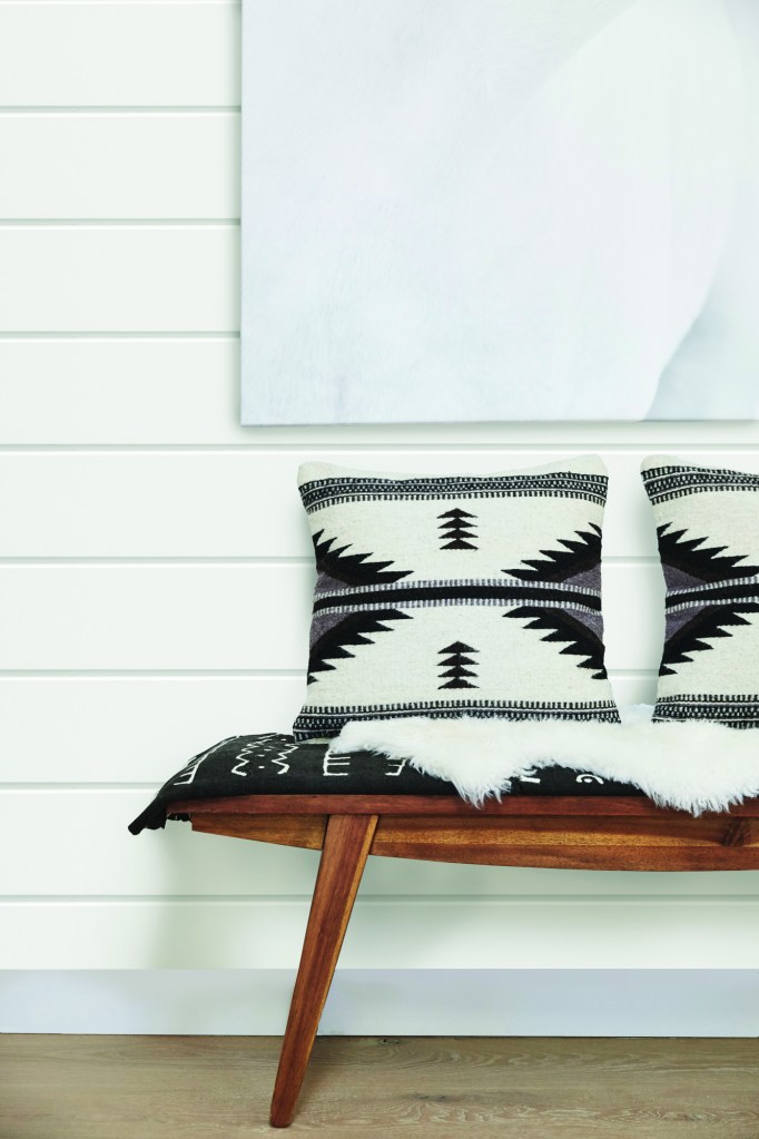 Wood bench with pillows in farmhouse hallway of small cottage home