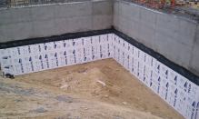 Rigid foam insulates a foundation wall and helps protect the damp-proofing during back fill at the Newport Beach Civic Center.