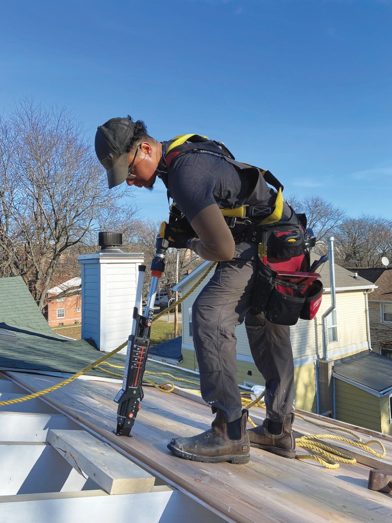 A worker uses a Simpson Strong-Tie Timber Drive vertically, from a standing position, as the tool was designed to be used.