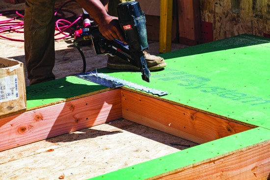 … and strap ties or other connections to complete the load path between floors. (Please note: In the photo above, the author is using a positive-placement nailer to align nails in the strap-tie holes. Don't do this with an ordinary air nailer.)