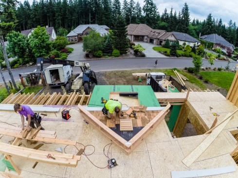 Building faster and safer. Tim Uhler installs the siding, vent, and eaves on rake walls before lifting them in place.