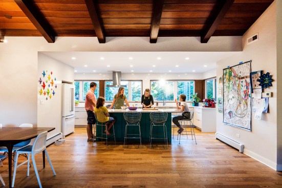 Here, too, fewer upper cabinets provide space for more windows and ample wall space. Again white is used to contrast to the darker wood ceiling and floor. Lots of wall space splashed with color, textrue and family artwork provides a personalized touch.