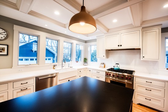 This kitchen demonstrates the trend toward having few upper cabinets in lieu of more windows and ample wall space. While white-on-white is in decline, white is used here to contrast with a darker island.