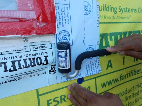 Step 7 (cont.). Side Flashing. Pay special attention where the side flashing laps on to the sill flashing; J-roll the lap to ensure adhesion. Nailing flanges typically have mitered corners, which are “welded.” The resulting welded seams often create raised surfaces, which cause the SAF to bubble and wrinkle at this critical juncture. Ideally, the SAF should lay flat on the fin, transitioning to the sill flashing without fish mouthing. This is an area I suggest sealant be applied at the edge of the membrane to prevent water from passing under the SAF.  See steps 10 and 11.