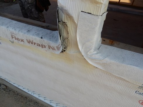 The flexible flashing shown here was not properly J-rolled and didn’t adhere to the drainable housewrap. It’s doubly important to J-roll SAF to drainable WRBs due to their wrinkled (or dimpled) surface. Also, if using a flexible flashing, ensure the product is correctly applied without creating wrinkles, and without overstretching the material. Ensure the inside corners are tight to the RO and, if need be, apply staples at the outer radius edge to avoid withdrawal of the material.