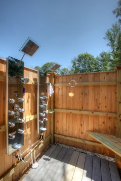Outdoor showers can be as simple as a hose with a garden nozzle hung on a wall. Or they can be as high-tech as an indoor shower with multiple showering stations, elaborate full-body shower systems and rainfall shower heads.